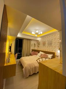 圣费尔南多Chic Hideaway at Azure North Bali Tower的一间卧室配有一张大床、一张书桌和一张四柱床。