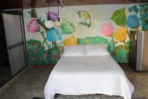 拉维加el paraíso de Butulú 1的卧室配有一张白色床,墙上挂有绘画作品