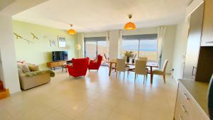 爱琴娜岛Villa Harmonia的一间带红色椅子的客厅和一间餐厅