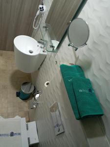 胡塞马Hôtel La Perla的浴室设有水槽、镜子和绿色毛巾