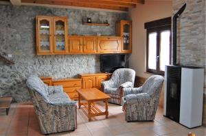 Casa para 5 personas con terreno en La Franca的厨房配有椅子、冰箱和桌子