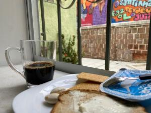 萨尔瓦多Barra Porto - Suítes & Kitnets的盘子,盘子上放着面包,咖啡,咖啡