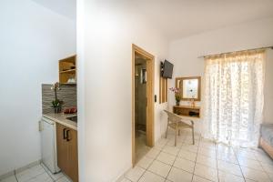 埃拉福尼西岛SMAROULA的客房设有厨房、床和书桌。