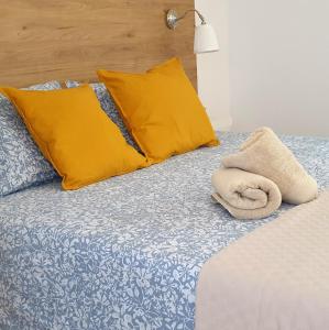 格拉纳达Road Sierra 95 Habitación privada con baño y zona de cocina的一张带黄色枕头的床和毛巾