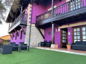 伊诺赫多诺利亚之家宾馆的紫色的建筑,在草地上摆放椅子