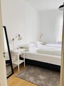 布伦迪欧斯Riverside Hostel的白色卧室配有床和书桌