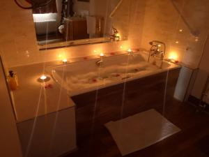 Catstone Lodge的浴室配有带灯和镜子的浴缸