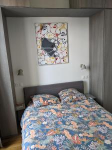 巴黎Trocadéro- 2 pièces lumineux的卧室配有一张床,墙上挂着一幅画
