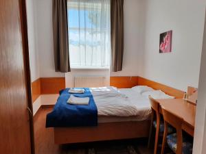 索波特米拉华酒店的一间卧室配有一张床、一张桌子和一个窗户。