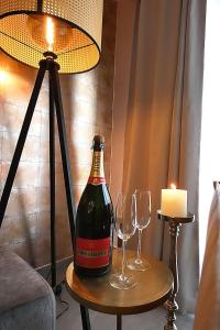 列日SuiteDreams - Relax Suite Liège的桌子上一瓶葡萄酒和两杯