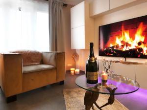 列日SuiteDreams - Relax Suite Liège的客厅配有一瓶葡萄酒和一个壁炉