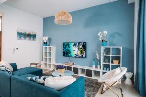 拉斯阿尔卡麦Family vacation villa with private pool and access to beach的客厅拥有蓝色的墙壁和蓝色的沙发