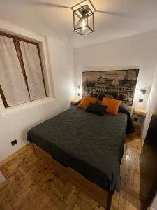 辛特拉Apartamento Grace的一间卧室配有一张带橙色枕头的大床