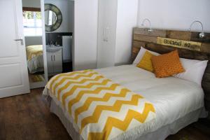 开普敦惬意时光公寓 - 开普敦的一间卧室配有一张带橙色和黄色枕头的大床