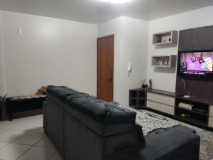 沙佩科Aconchego的带沙发和平面电视的客厅