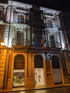 利亚内斯Hotel Puerto de Llanes的一座在晚上有旗帜的建筑