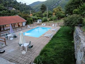 曼泰加什Quinta de Leandres的房屋旁的游泳池配有椅子和遮阳伞