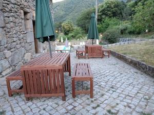曼泰加什Quinta de Leandres的庭院里摆放着长椅和遮阳伞