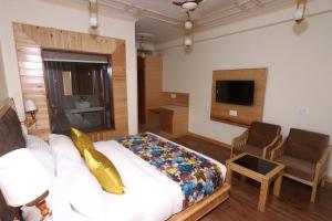 KatrainNiranya Guest House的一间卧室配有一张床、一张沙发和一把椅子