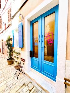 罗维尼Rooms & Apartments La Casa di Loreto的建筑物一侧的蓝色门