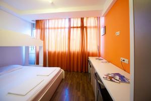 萨格勒布方科隆旅馆的一间卧室设有一张床和橙色的墙壁