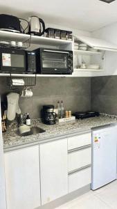 布宜诺斯艾利斯Amazing Apartment in Palermo Hollywood!的厨房配有白色橱柜、水槽和微波炉