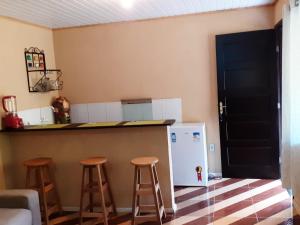 圣佩德罗塞拉Casa Vênus的厨房配有2张凳子和带冰箱的台面