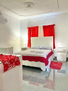 Licey al MedioComplejo Ecoturistico Rancho Cielo的一间卧室配有一张带红色窗帘的大床