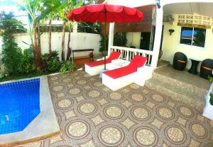 拉迈Lamai villa的一个带两把椅子和一把遮阳伞的庭院和一个游泳池