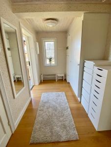 诺尔泰利耶Villa i Norrtälje的一条带白色门的走廊,地毯