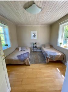 诺尔泰利耶Villa i Norrtälje的一间卧室设有两张床和天花板