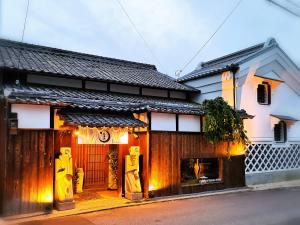 松山考米卡麦哈玛民宿的一座带大门的房子和一座带灯的建筑