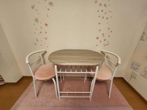 神户Takaraboshi room 301 Sannomiya 10 min的墙上的桌子和椅子