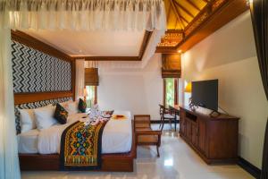 努沙杜瓦Giri Bhagawan Villas & Spa的一间卧室配有一张床和一台平面电视
