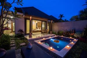 乌布Villa Mandi Ubud的夜间别墅后院的游泳池