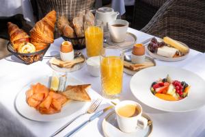 梅里尼亚克Le M & Spa by Hôtels & Préférence的餐桌上摆放着早餐食品和饮料