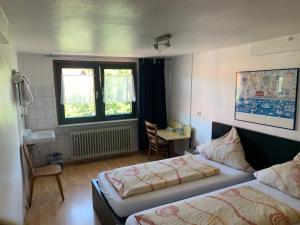 FischbachLandgasthaus Klosterhof的一间卧室设有两张床、一张桌子和一个窗口