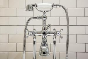 特拉维夫马克特奥斯 - 安阿特拉斯精品酒店的白色瓷砖浴室内的镀铬淋浴头