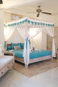 乌鲁瓦图Luz_ita Sunshine Villa的一间卧室配有一张带天蓬的床
