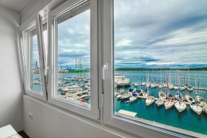 普拉Apartment Marina with sea view的享有码头景致的窗户,设有船只