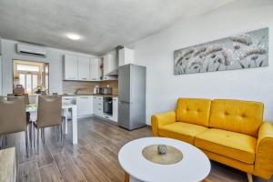 普拉Apartment Marina with sea view的客厅配有黄色的沙发和桌子