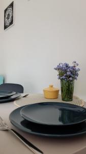 库尔迪加复古安娜公寓的一张桌子,上面有黑色的板子和花瓶