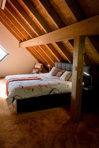 HirschbachAll Senses Ferienwohnung的阁楼内的一张床铺,设有木制天花板