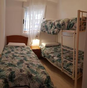 奥罗佩萨德尔马Marina dor Frontal 1ª línea的一间卧室设有两张双层床和一扇窗户。