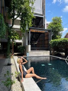 清迈Lamphu House Chiang Mai - SHA Extra Plus Certified的女人坐在游泳池里