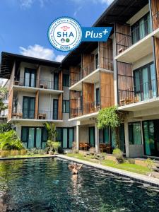 清迈Lamphu House Chiang Mai - SHA Extra Plus Certified的在酒店前的游泳池游泳的人
