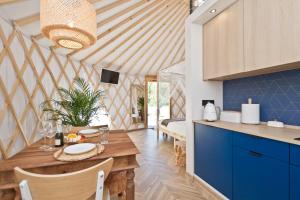 鲁比亚托沃JURTLANDIA jurta BOHO的厨房以及带木桌和蓝色橱柜的用餐室。