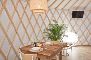 鲁比亚托沃JURTLANDIA jurta BOHO的蒙古包内带木桌的用餐室