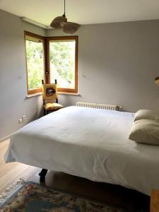 特尔菲伦La Clé de la Forêt的卧室设有一张白色大床和一扇窗户。