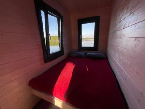 BērzgaleAQUA Bērzgale的配有2扇窗户的客房内的一张红色的床